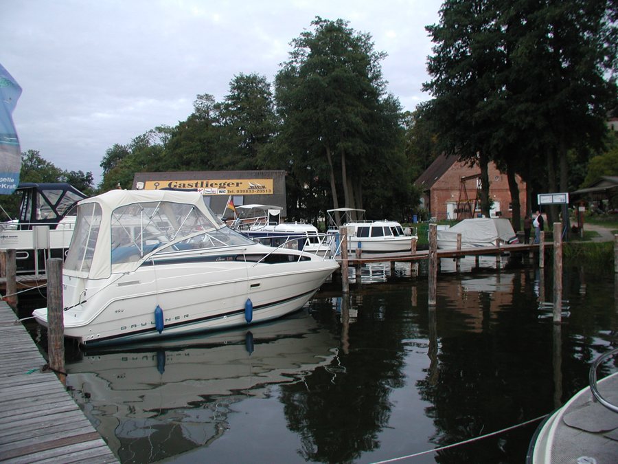 Hausboote liegen an einem Hafensteg in Mirow.