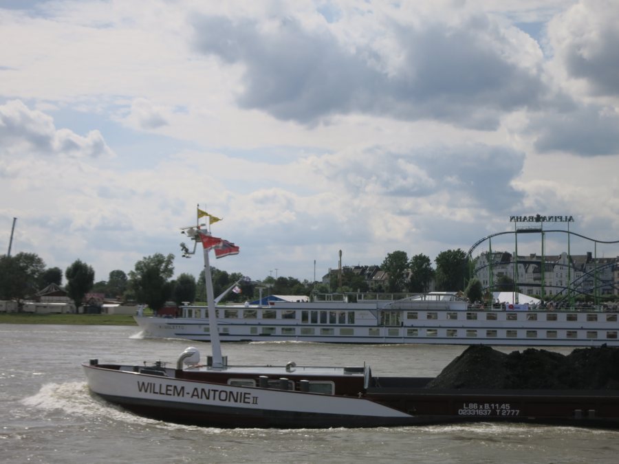 Flusskreuzfahrtschiff und Frachtschiff auf dem Rhein bei Düsseldorf.