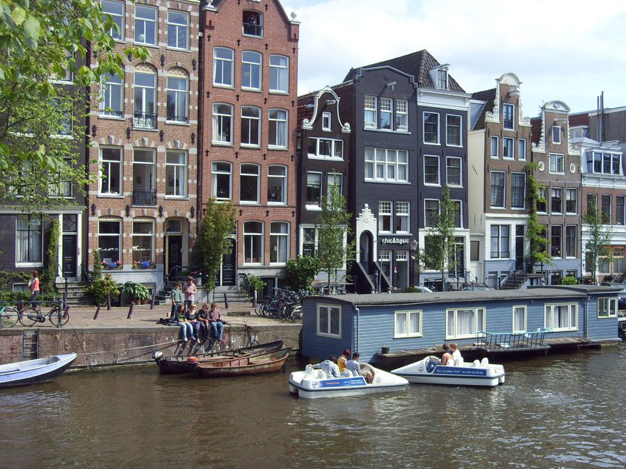 Hausboote und kleinere Boote liegen am Kanal in Amsterdam.